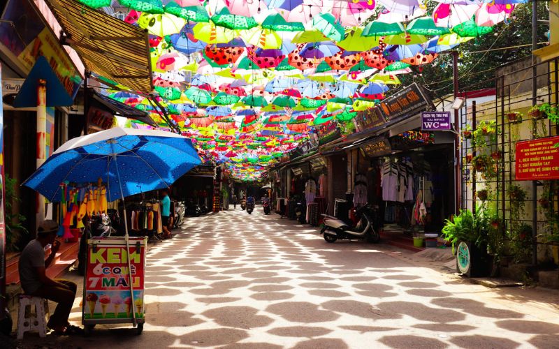 Colorful umbrellas brighten the walkway and bring playful energy to the village.